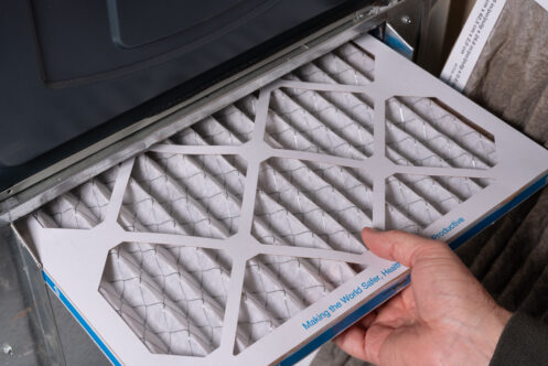 Man replacing dirty furnace filter in home